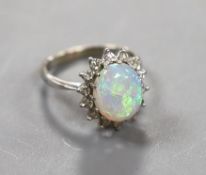 An 18ct white metal, white opal and diamond set oval cluster ring, size G, gross weight 2.9 grams.