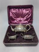 A cased late Victorian Scottish repousse silver three piece tea set, Hamilton & Inches, Edinburgh,