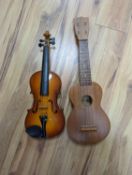 Four 3/4, half and quarter size violins and two ukuleles.