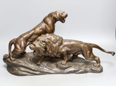 A patinated spelter group of a lion and lioness, 53 cms wide.