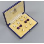 A modern cased seven (ex 9) piece 9ct gold, mother of pearl and seed pearl set dress stud set, gross