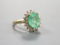 A modern 14k yellow metal, emerald and diamond set oval cluster ring, size M, gross weight 5.9