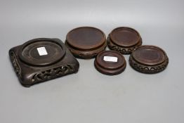 Five Chinese carved hardwood stands, largest 15cm.