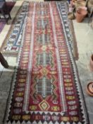 A Kilim polychrome flatweave runner, 380 x 118cm (holed)