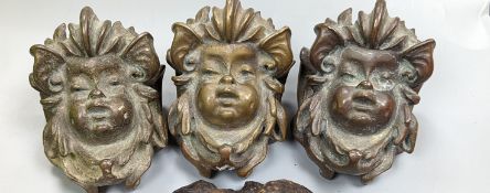 A set of three cast bronze mask-form furniture mounts, 9cm. high, and an iron ceiling rose fitting