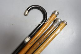 Four silver topped walking canes, longest 85 cms high.
