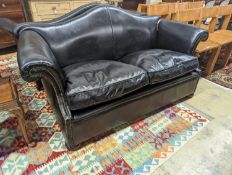 A pair of black leather scroll arm two seater settees on flat bun feet, length 184cm, depth 80cm,
