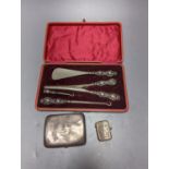 A George V silver cigarette case, an earlier silver vest case and a cased set of button hooks,