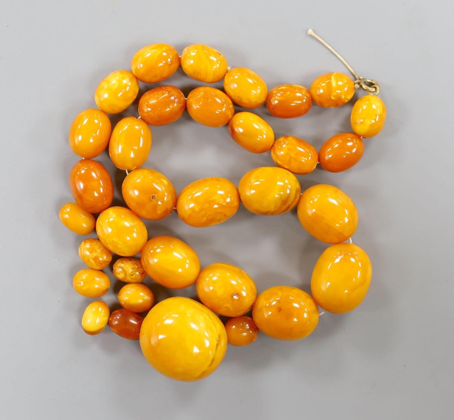 A single strand graduated oval amber bead necklace, 43cm, gross weight 51 grams and a few loose - Image 2 of 3