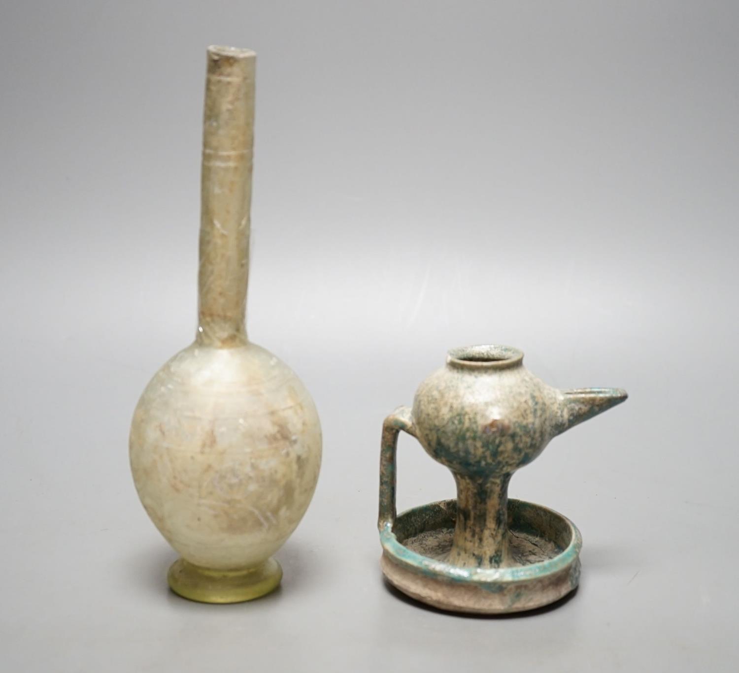 A Kashan oil lamp, 13th/14th century, and an early Islamic glass bottle.Bottle 22 cms high.