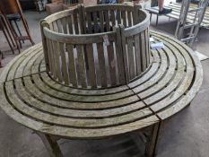 A weathered teak four section tree seat, aperture 90cm diameter, the seat 200cm diameter, height
