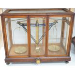 L. Oertling, London - mahogany cased set of brass pan-scales, cabinet 74cm wide