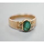 A yellow metal, oval cut emerald and six stone diamond chip set ring, size O, gross weight 3 grams.