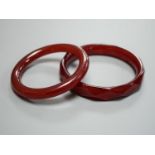 Two cherry amber bangles, gross weight 53 grams.