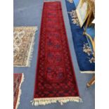 An Afghan red ground runner, 360 x 68cm and a Bokhara rug