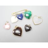 An 18ct safety pin, 47mm, hung with seven assorted heart shaped hardstone pendants or charms, two
