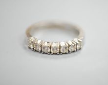 A modern 18k white metal and seven stone diamond set half eternity ring, size M, gross weight 4.4.