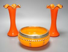 A tangerine glass bowl with silver plated mount to rim and a pair of spill vases, in the style of