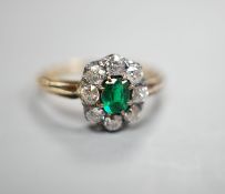 A yellow metal, emerald and diamond set oval cluster ring, size M/N, gross weight 3.1 grams.