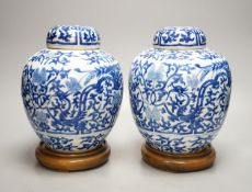 A pair of Chinese blue and white ginger jars and covers, 22cm, On stands