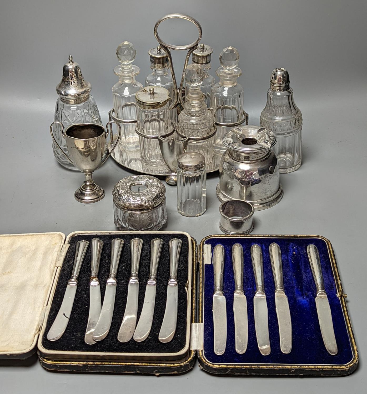 A plated cruet stand, two cased sets of silver handled tea knives, a silver domed ashtray(a.f.)