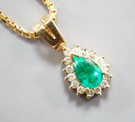 A modern 18k, emerald and diamond cluster set pear shaped pendant, overall 21mm, on an 18k chain,