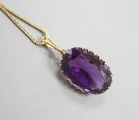 An early 20th century yellow metal mounted oval cut amethyst pendant, overall 37mm, on a yellow