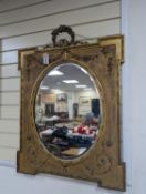 A Victorian style rectangular giltwood and gesso wall mirror, floral swag to top, with oval plate,