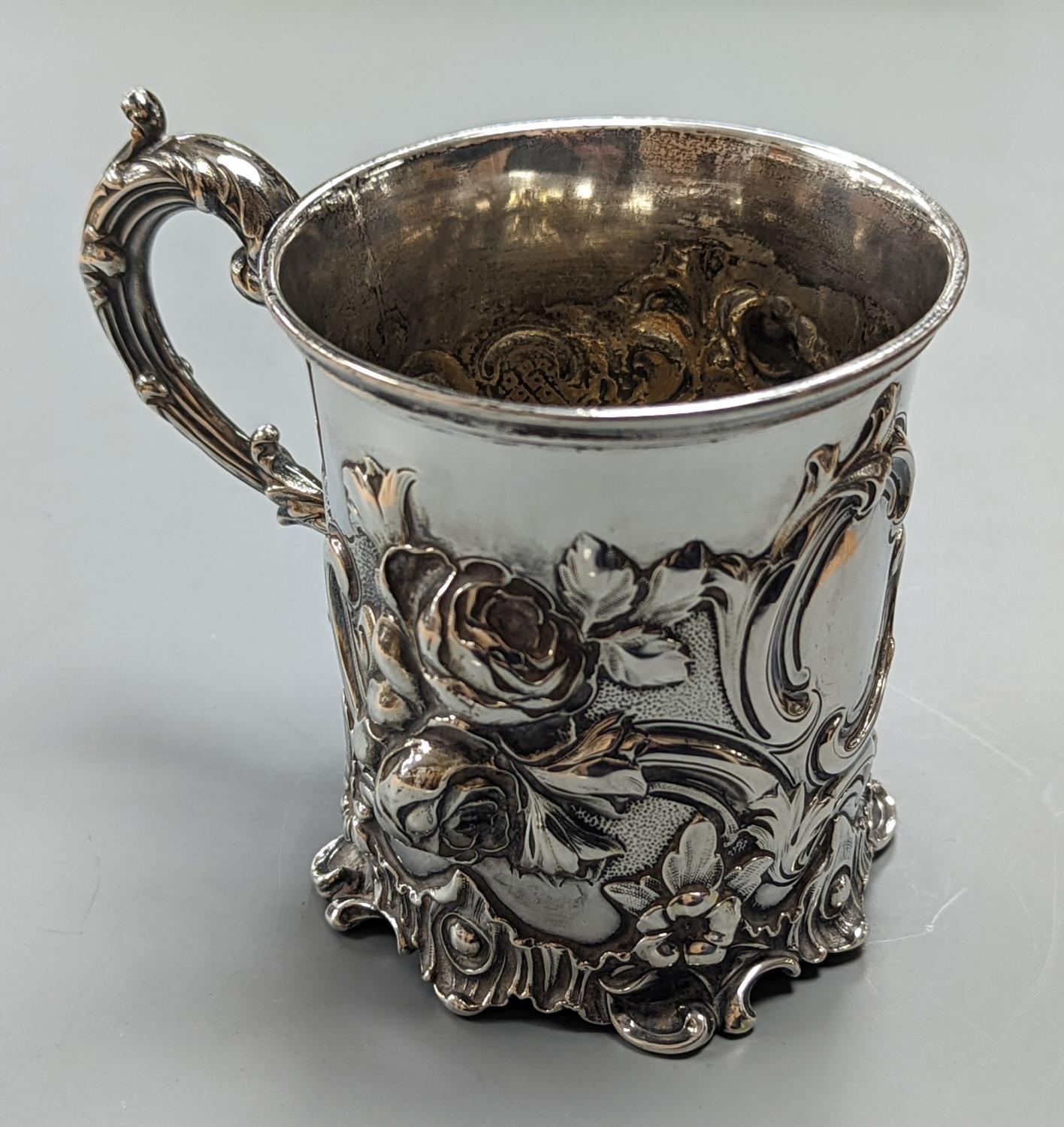 A Victorian embossed silver christening mug, decorated with roses amid scrolls, The Barnards,