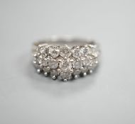A modern 10k white metal and three row graduated diamond cluster set dress ring, size L, gross