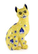 A Gallé yellow faience model of a seated smiling cat, c.1885,with applied glass eyes, decorated in