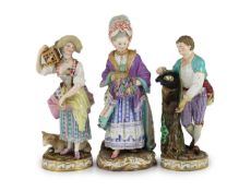 A pair of Meissen figures of a youth with a bird’s nest and a maiden holding a bird in a cage and