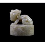 A Chinese celadon and white mottled jade ‘lion-dog’ seal, 18th/19th century,the beast sitting upon