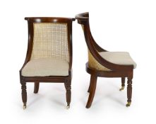 A pair of late Regency mahogany bergere side chairs,with overscrolled top rails to the cane