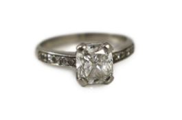 A modern platinum and single stone brilliant cushion cut diamond, with diamond set shoulders,with