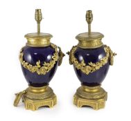 A pair of Louis XVI style ormolu mounted bleu du roi porcelain table lamps,with floral swag