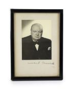 A signed black and white photograph of Winston Churchill by Vivienne,showing him in 1951 seated