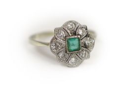 A 1920's white gold, millegrain set emerald and diamond cluster ring,size P, gross weight 2.7