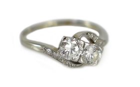 An 18ct gold and two stone diamond crossover ring, with millegrain diamond chip set shoulders,the