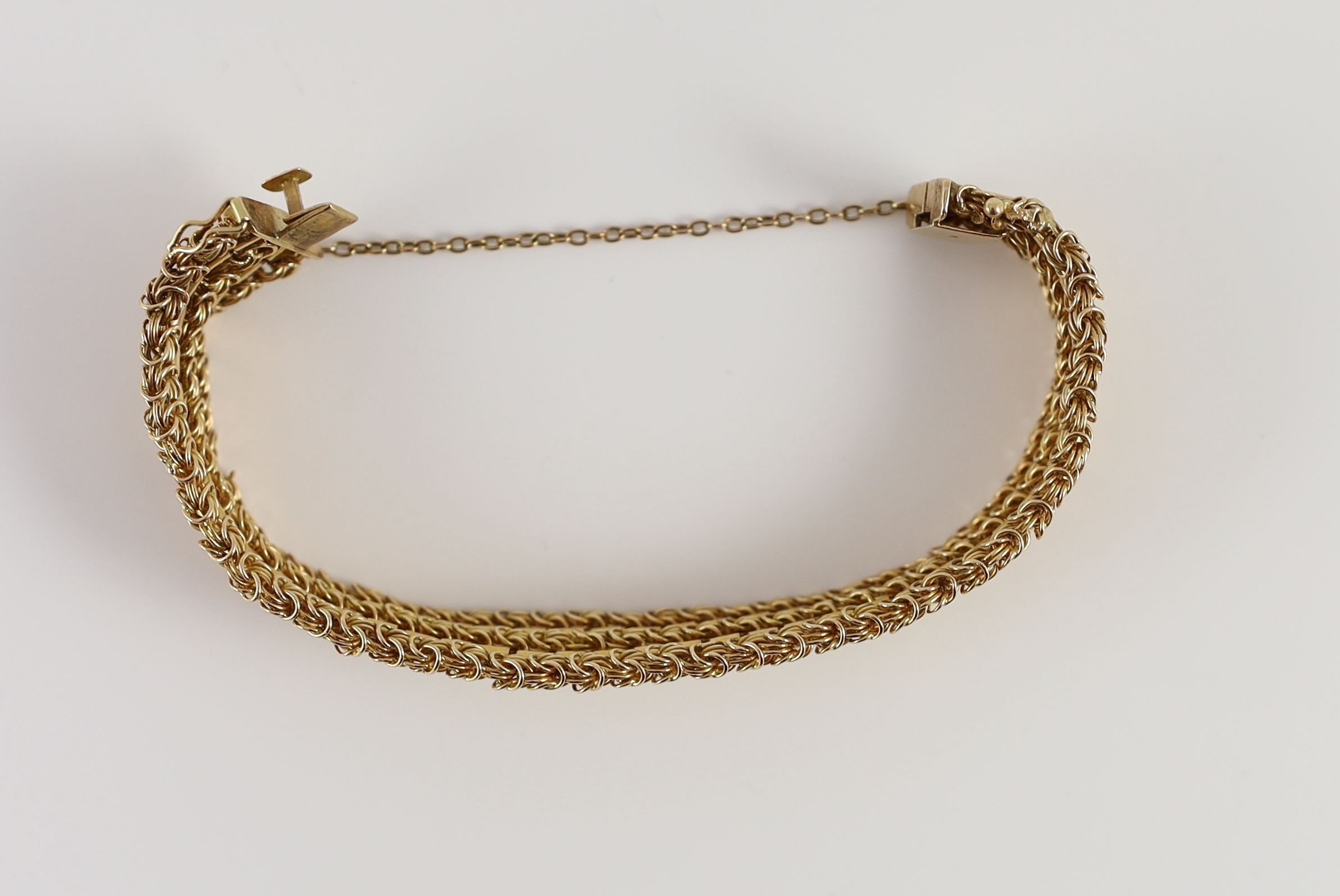 A 20th century 18k gold interwoven three row bracelet,with safety chain. interior length approx. - Image 3 of 3