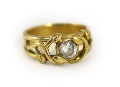 A modern pierced 18ct gold and solitaire diamond set band,the setting modelled as scrolling