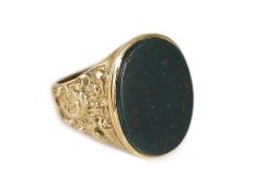 A 1970's 9ct gold and oval bloodstone set signet ring,with ornate carved shoulders, size P/Q,