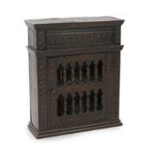 A 17th century oak dole cupboard,with ovolo carved frieze and baluster turned barred door with