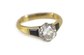 A modern 18ct gold and single stone diamond ring, with trapeze cut sapphire set shoulders,the