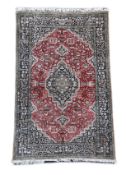 An early 20th century Caucasian silk red ground rug,with central stepped lozenge central