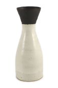 § § Dame Lucie Rie (1902-1995), a stoneware conical vase,covered in a cream glaze, the flared neck