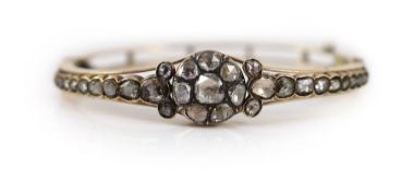 A Victorian style gold and rose cut diamond cluster set hinged bangle, with graduated rose cut