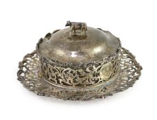 An Edwardian pierced silver butter dish and cover by Charles Stuart Harris & Sons,with cow finial