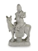 A Chinese blanc-de-chine equestrian group of Guandi seated astride a horse, Dehua kilns, Kangxi