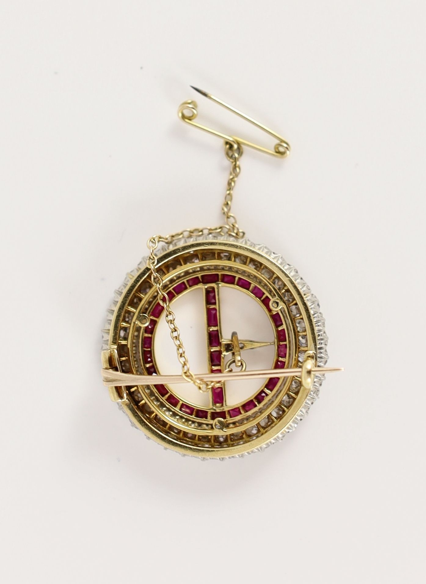 A 20th century gold and platinum, ruby and diamond set openwork circular 'buckle' brooch,with safety - Image 2 of 2